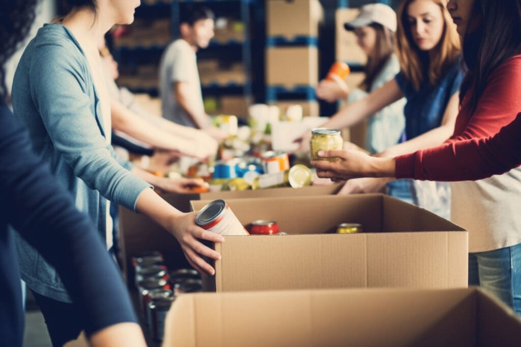 A group of unrecognizable people volunteering at a local food bank