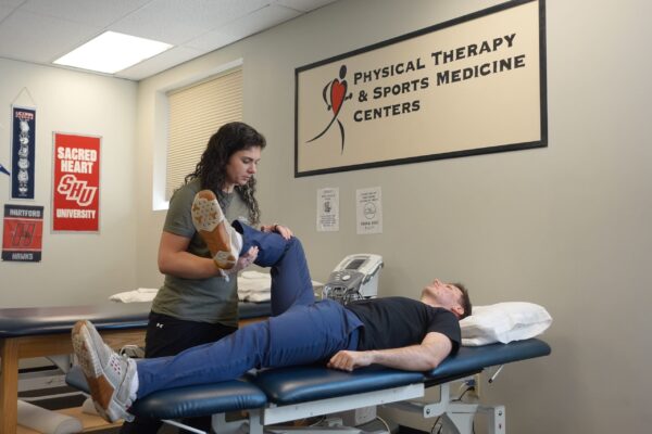 Physical Therapy & Sports Medicine Centers (PTSMC) Newington physical therapist assessing male patient's hip mobility